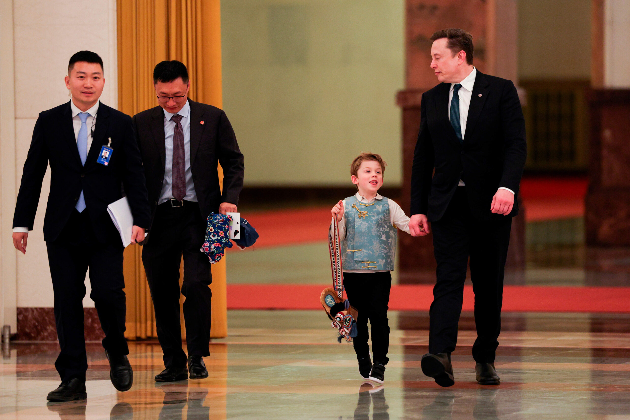 Elon Musk arrive en compagnie de son fils X Æ A-Xii pour la rencontre entre le Premier ministre chinois Li Qiang et des représentants du monde des affaires américain, au Grand Hall du Peuple à Pékin, le jeudi 14 mai 2026. © Go Nakamura