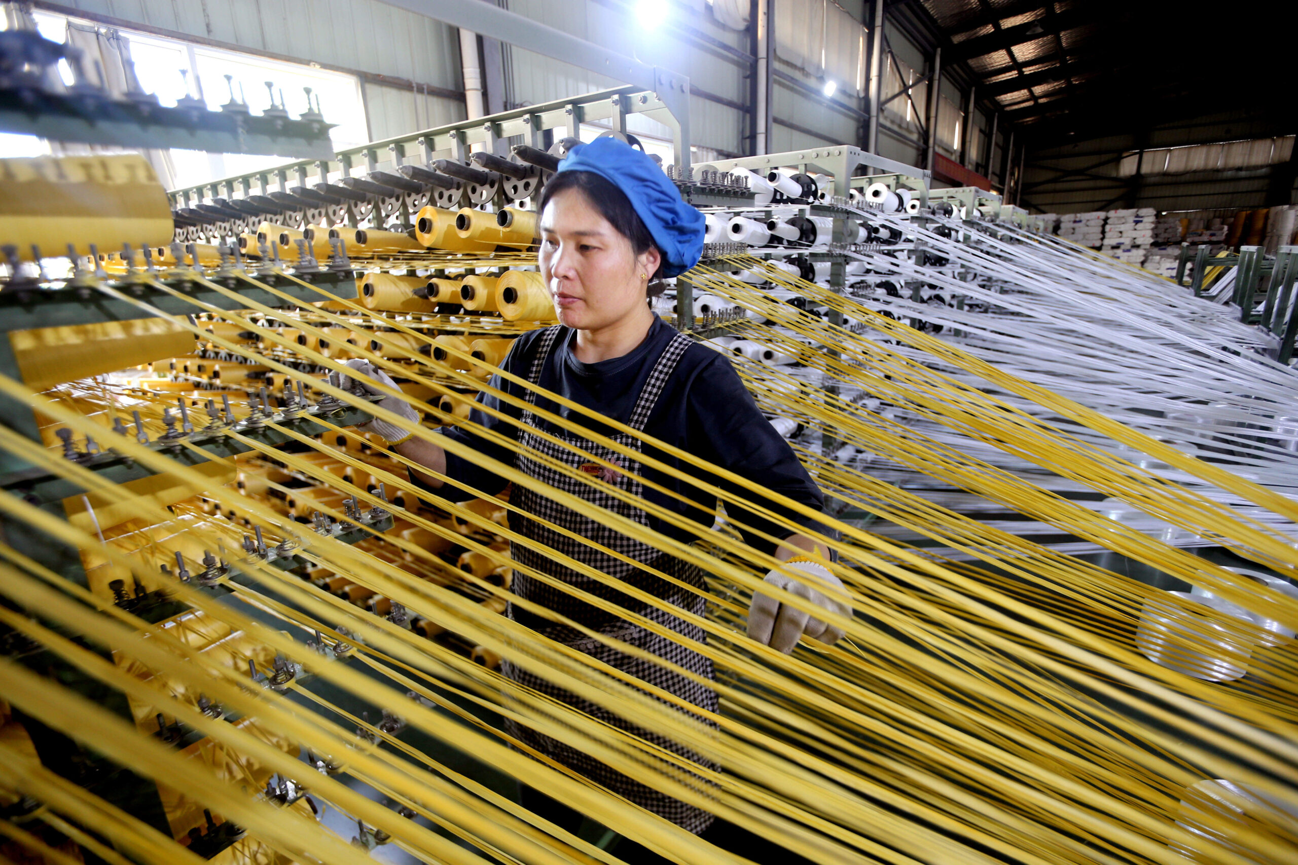 Les fils tissés par cette ouvrière serviront à la fabrication de sacs dans l'usine de Zhonghong, à Lianyungang, dans la province du Jiangsu, le 6 mai 2026. © CFOTO/Sipa USA