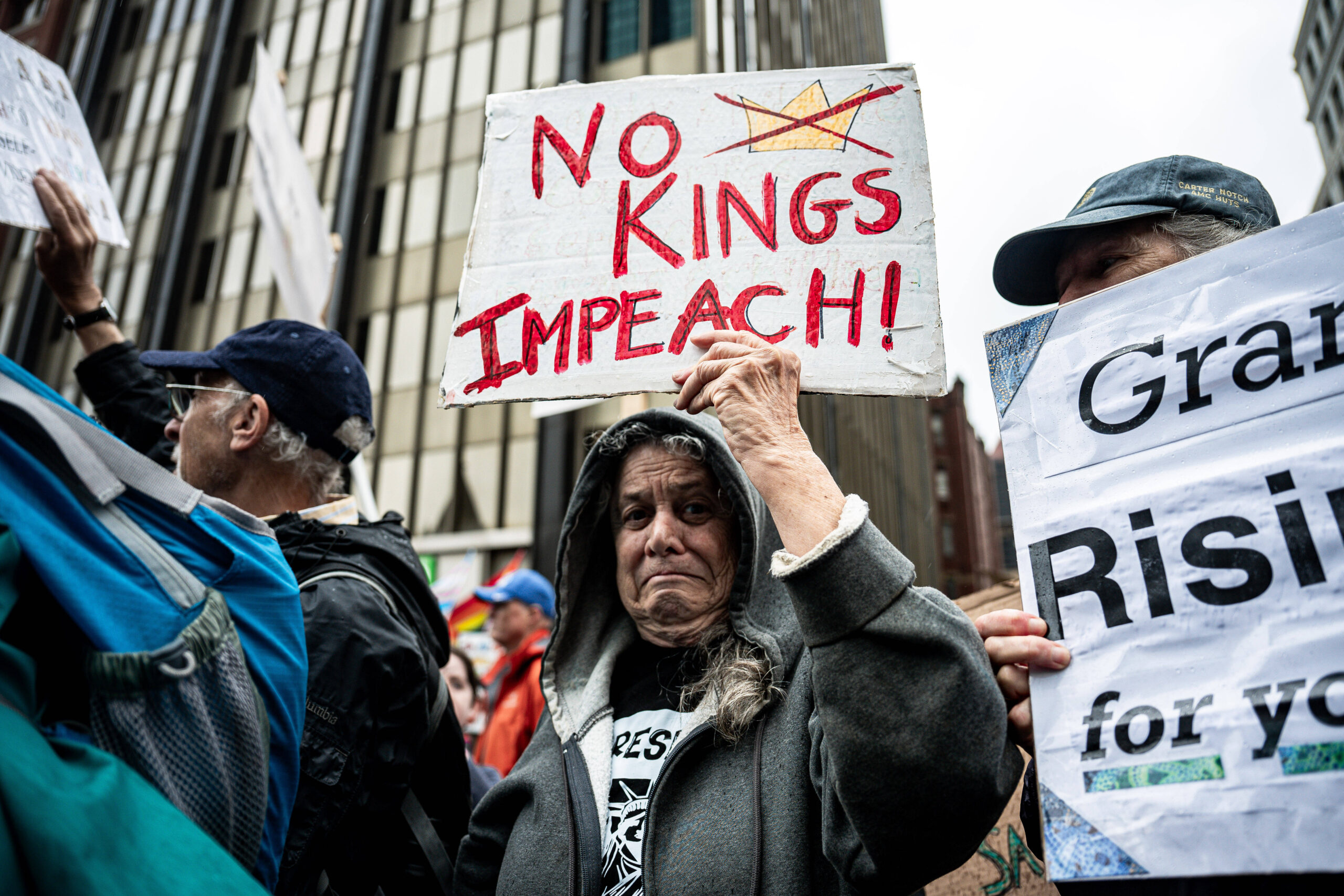À Boston, une manifestante brandit la couronne biffée du mouvement «No Kings», la ville du Tea Party contre le roi George, réactivée contre un autre pouvoir jugé royal. Photo : Ziyu Julian Zhu / Xinhua