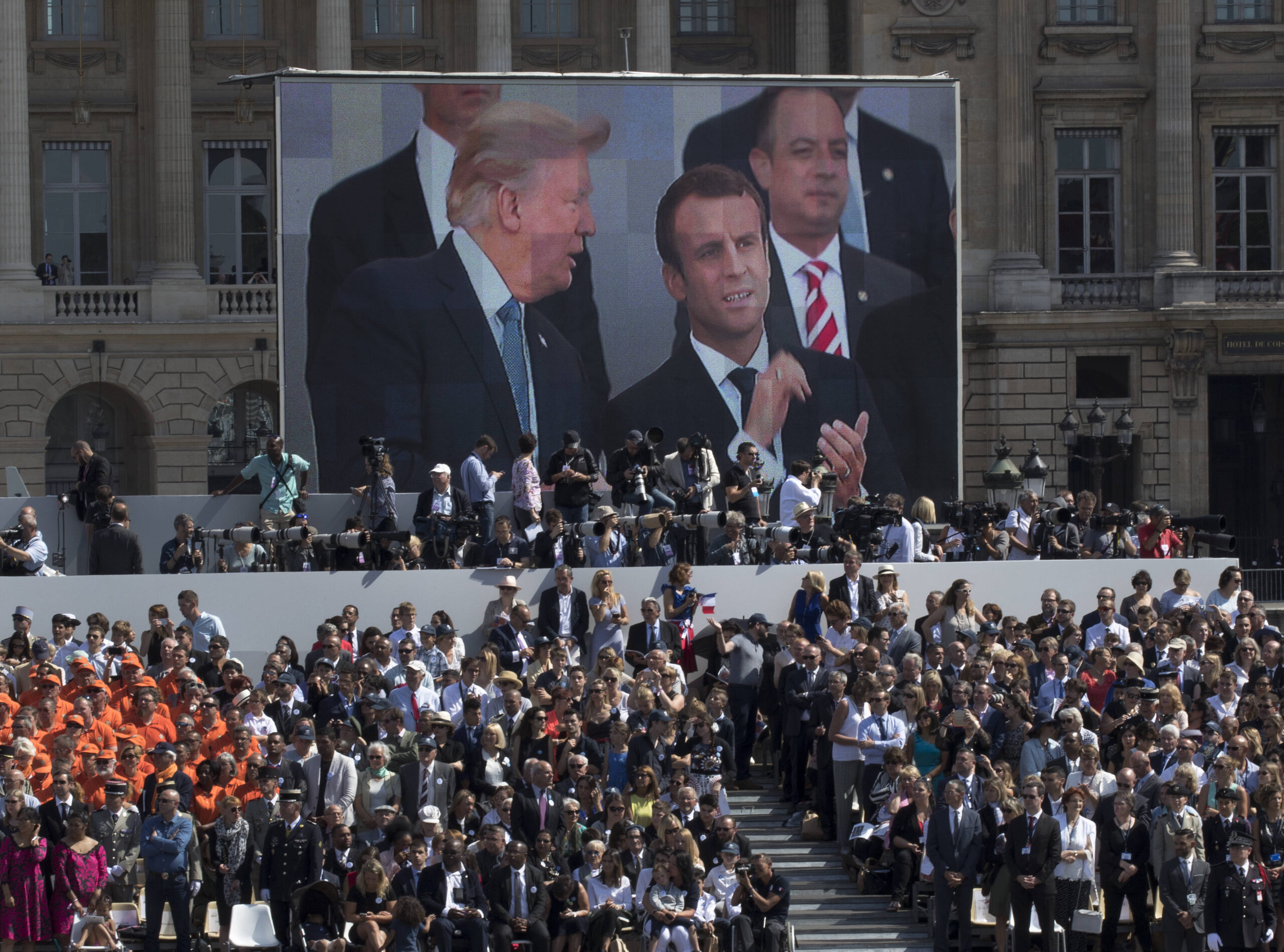 Place de la Concorde, Trump main sur le cœur, démultiplié par l'écran géant, la bannière étoilée déployée au pied de la tribune. C'est ici, en spectateur, qu'il découvre ce que la Cinquième République peut faire.