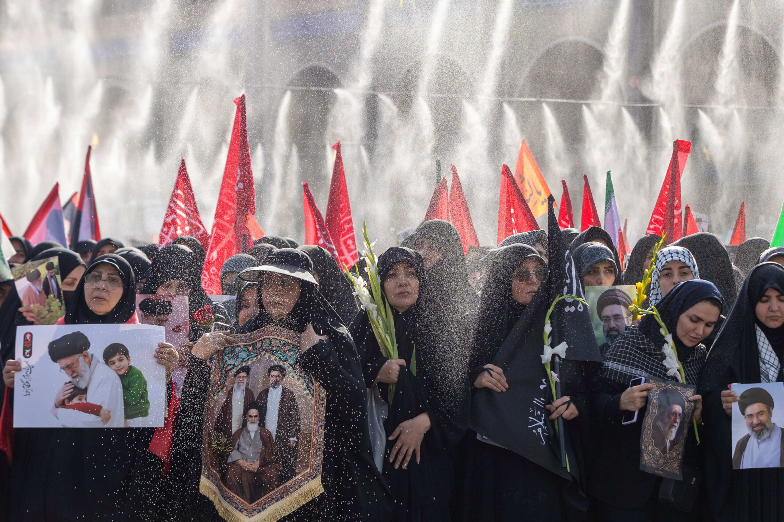 Celles qui se trouvent en tête de la procession brandissent des photos de l'ayatollah Khamenei, tandis que celles qui se trouvent à l'arrière brandissent des drapeaux. © Maryam Rahmanian/Shutterstock