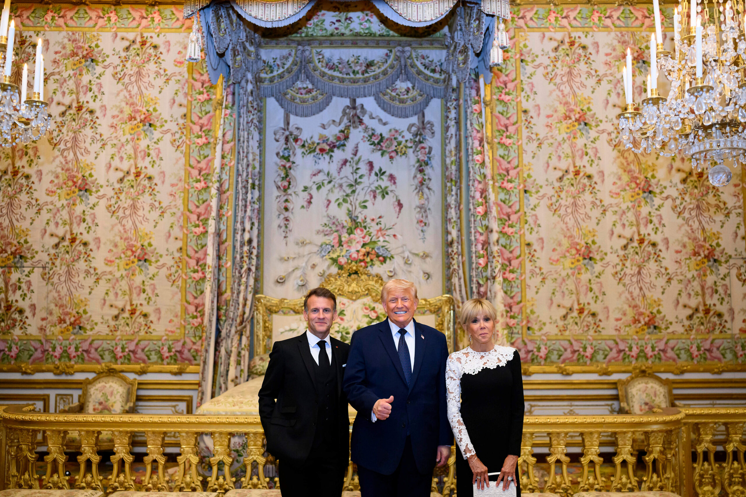 Le pouce levé dans la chambre de la Reine, devant le lit à baldaquin de Marie-Antoinette, le geste de Las Vegas rencontre le décor de l'Ancien Régime.