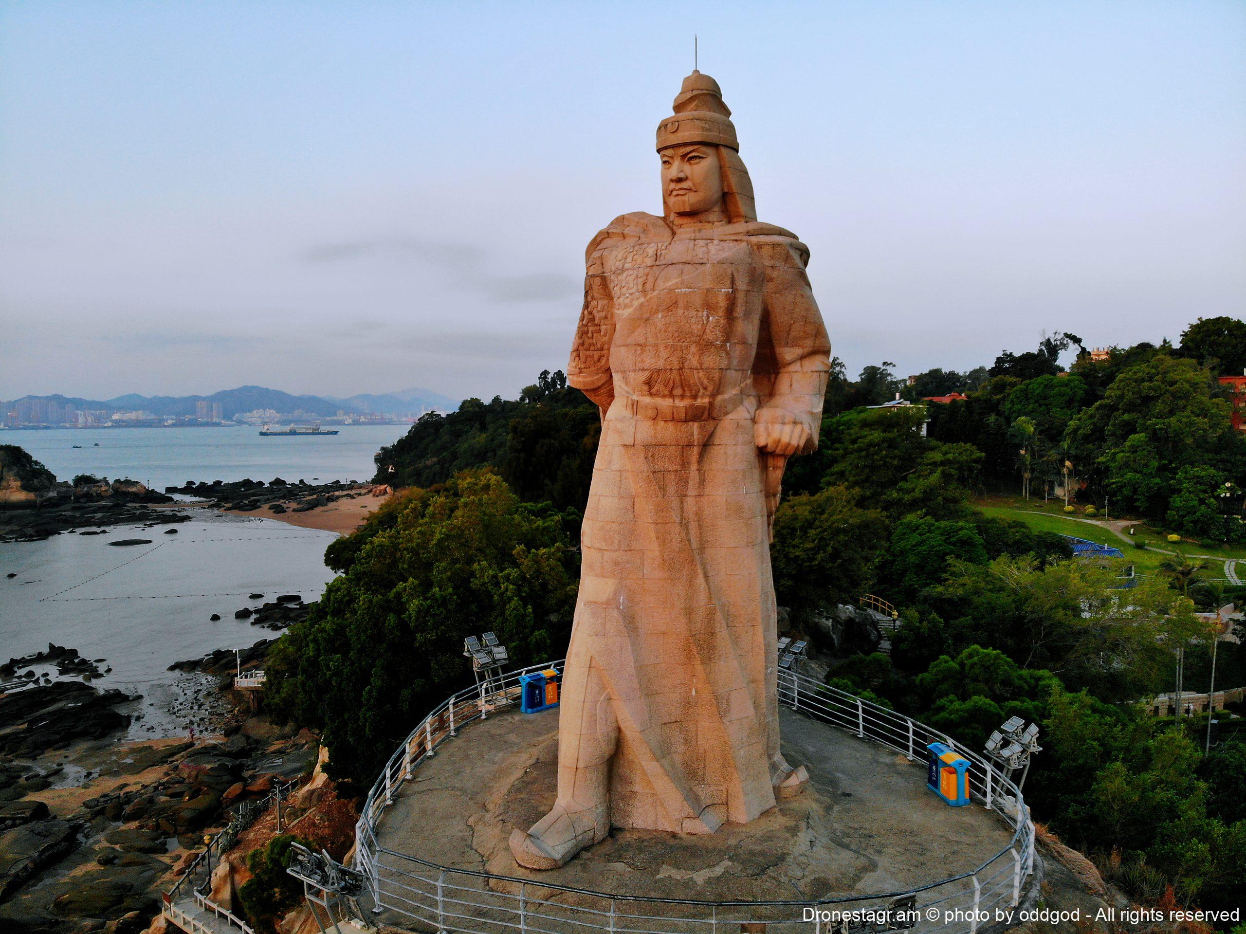 À la pointe de l'île de Gulangyu, à Xiamen, le colosse de granit érigé en 1985 fixe le détroit de Taïwan — l'île que Koxinga arracha aux Hollandais en 1662 pour en faire un bastion doté d'une administration calquée sur celle de l'Empire. Cette monumentalité témoigne d'un retournement contemporain : le « seigneur de la mer », dont la puissance s'était bâtie en marge du centre continental, est réapproprié par Pékin comme héros national, vainqueur des Européens et garant de la continuité territoriale chinoise à Taïwan.
