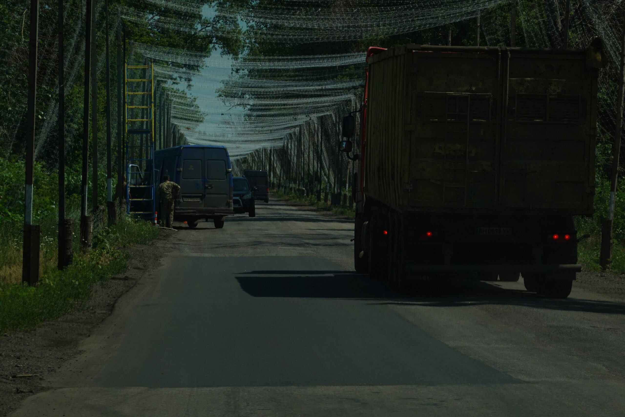 Réparation de filets anti-drones sur une route boisée non loin de Kramatorsk, le 7 juillet 2026.