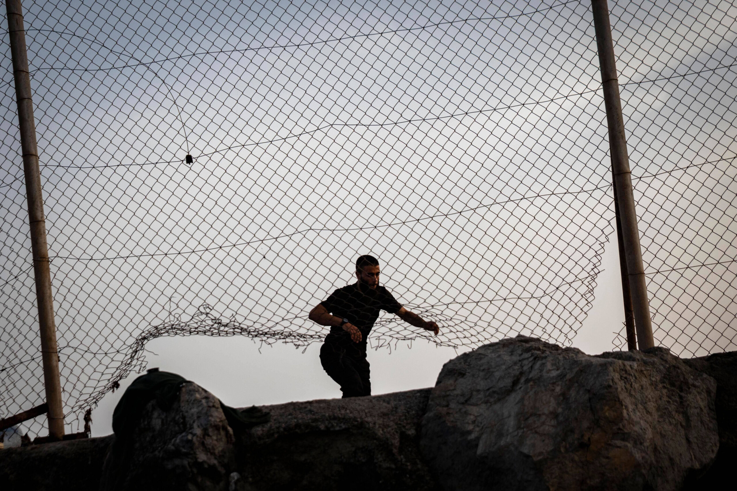 Un homme se glisse par une brèche du grillage près du poste-frontière du Tarajal, à Ceuta, le 31 juillet 2026. Photo : Samuel Vega