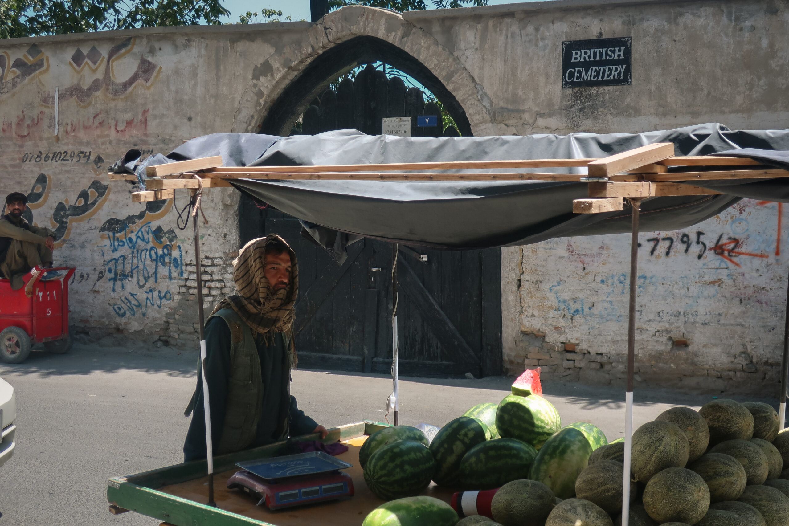 Un vendeur de pastèques devant le cimetière britannique de Kaboul, dans le quartier de Sherpur. Y reposent des soldats des trois guerres anglo-afghanes du XIXe siècle, puis des morts de l'OTAN. © Nicolò Sancassiani.