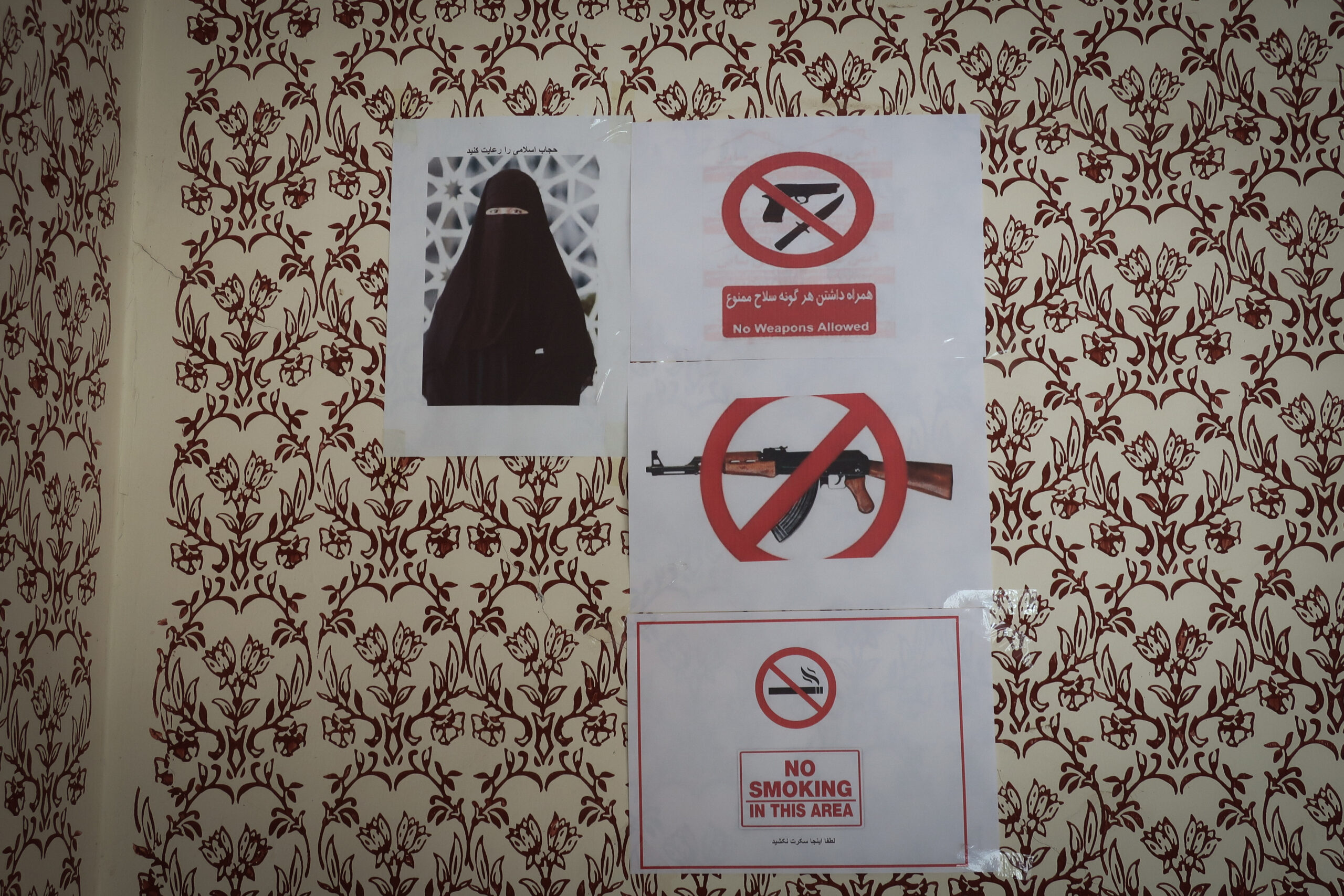 Le règlement d'une auberge de Kunduz , affiché à l'entrée : burqa obligatoire pour les femmes, kalachnikovs et pistolets interdits, défense de fumer. © Nicolò Sancassiani.