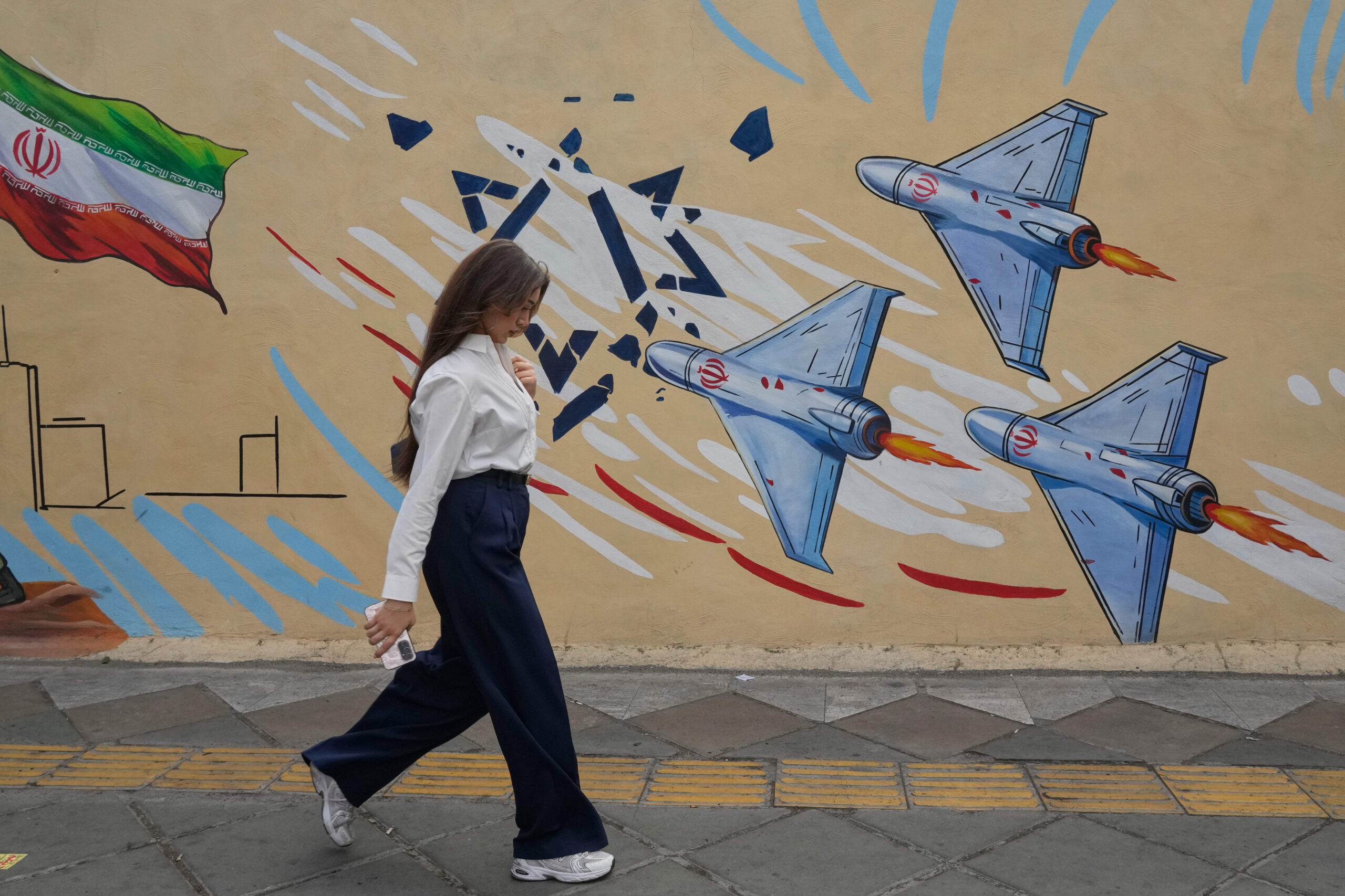 Une femme passe devant une fresque anti-israélienne à Téhéran, en Iran, le 17 mai 2026.