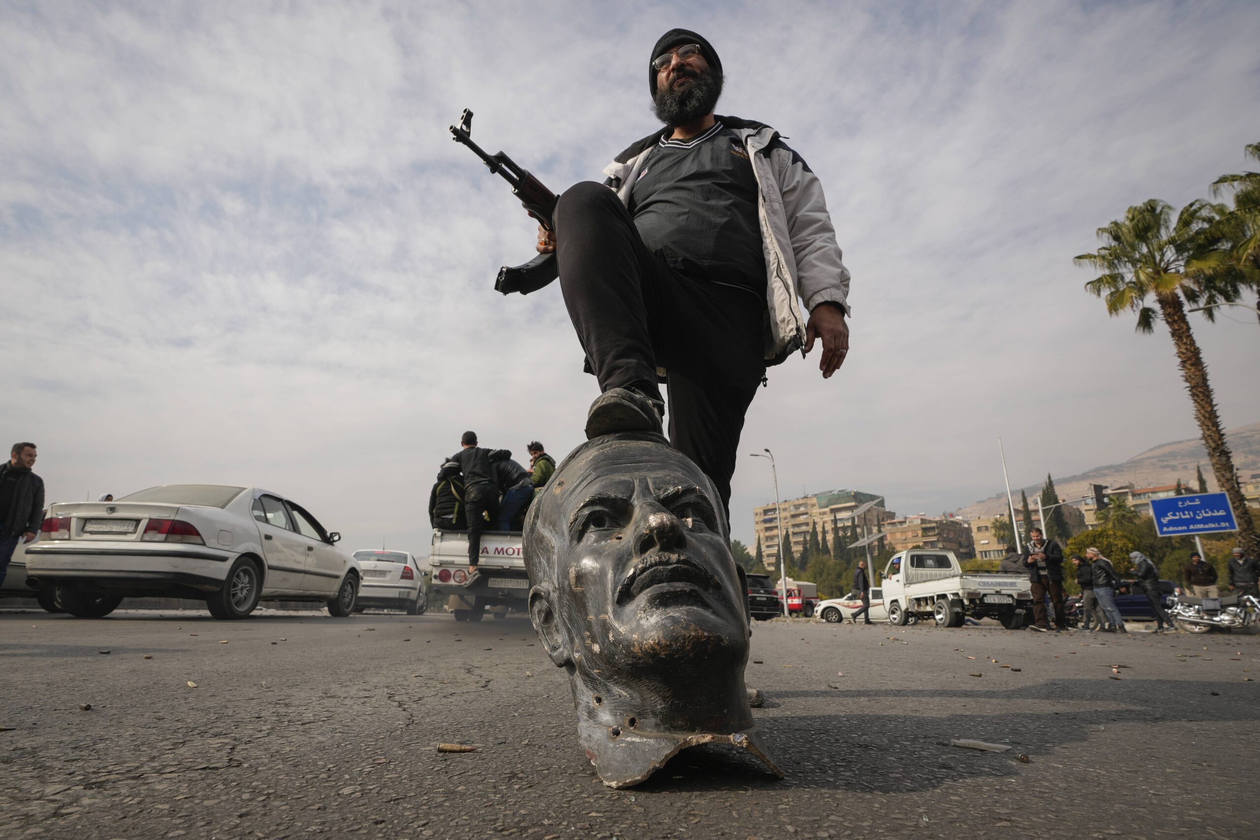Un combattente dell'opposizione calpesta un busto rotto del presidente siriano Hafez el Assad a Damasco, in Siria, domenica 8 dicembre 2024.  © AP Photo/Hussein Malla