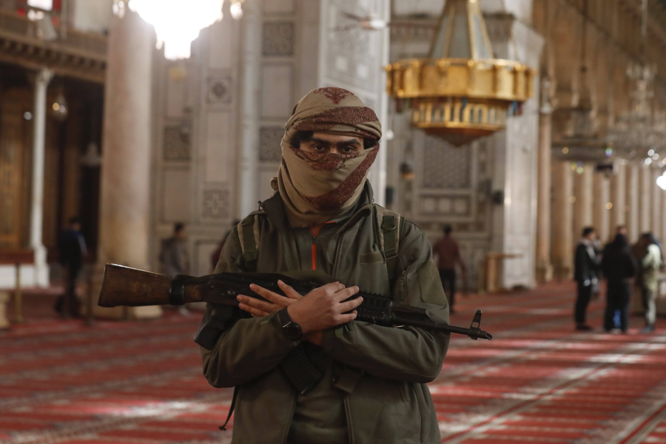 Un combattente dell'opposizione posa per una foto all'interno della Moschea degli Omayyadi a Damasco, in Siria, mercoledì 11 dicembre 2024. © AP Photo/Omar Sanadiki