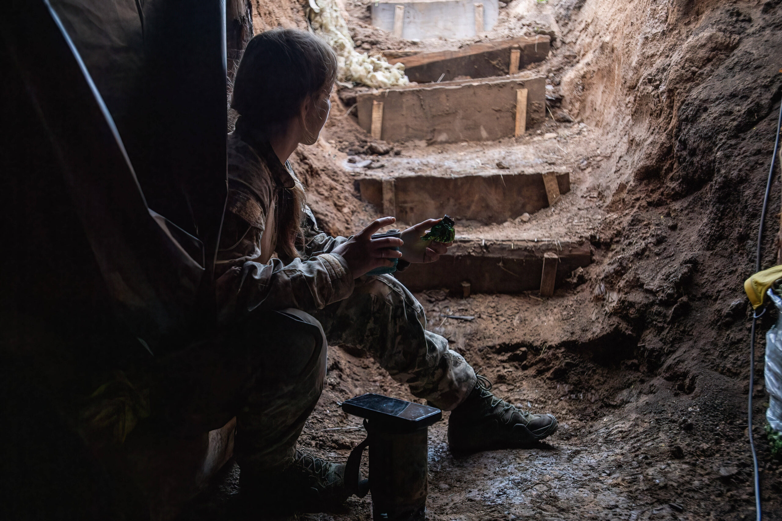 Una donna comandante di plotone (nome in codice “Shylka”) mangia all'interno del bunker utilizzato da un'unità ucraina di droni FPV della 92ª brigata. Foto di Laurel Chor (SOPA Images)