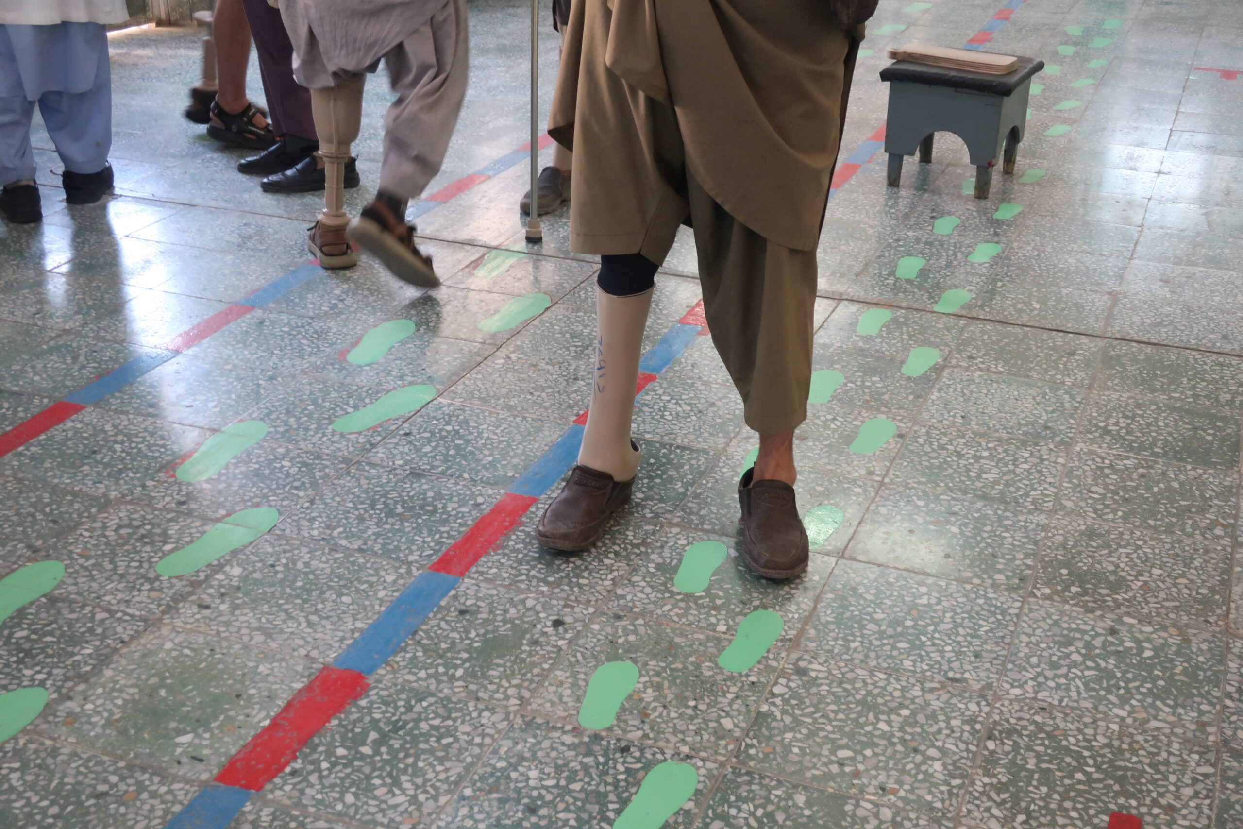 Sala di riabilitazione di un centro ortopedico a Kabul. Le impronte dipinte sul pavimento guidano i primi passi delle persone amputate che indossano protesi. In Afghanistan si contano circa 100.000 civili amputati, a fronte di oltre 15 milioni di mine sepolte dal 1979. © Nicolò Sancassiani.
