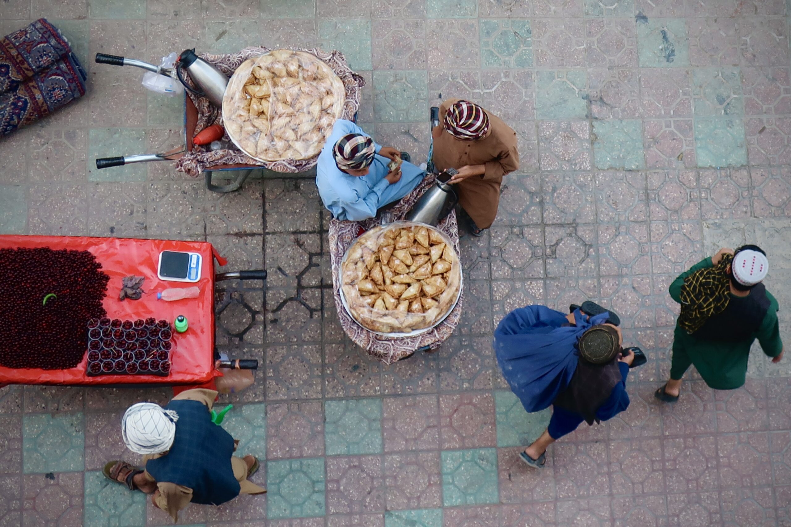 Venditori di ciliegie e dolci in una strada di Mazar i Sharif. Lo Stato talebano non produce nulla e non fornisce alcun servizio, ma riscuote tasse ovunque, persino dai venditori ambulanti. © Nicolò Sancassiani.