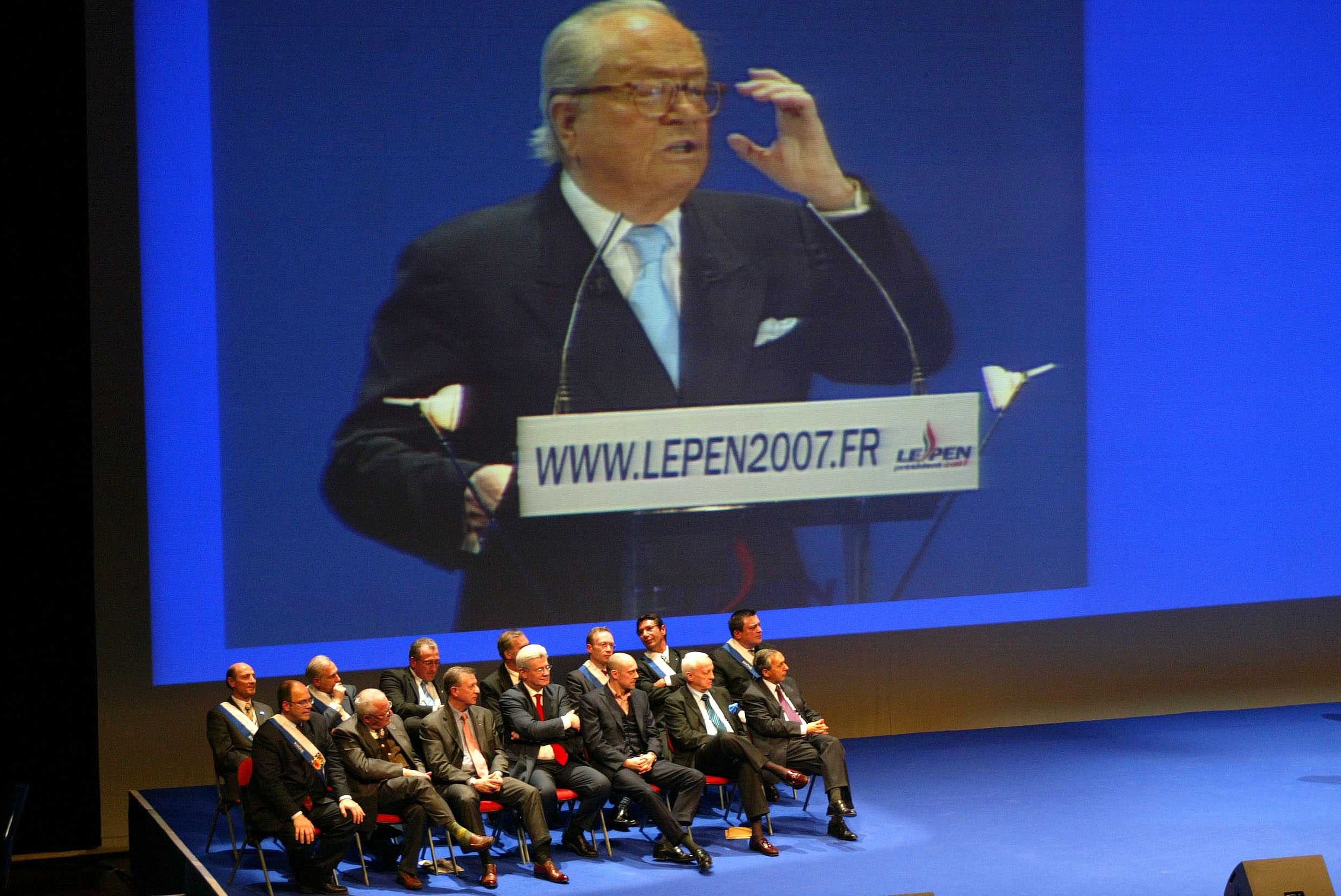 Durante questo comizio, Jean-Marie Le Pen tiene un discorso che viene trasmesso su un maxischermo. Alain Soral è presente sul palco.